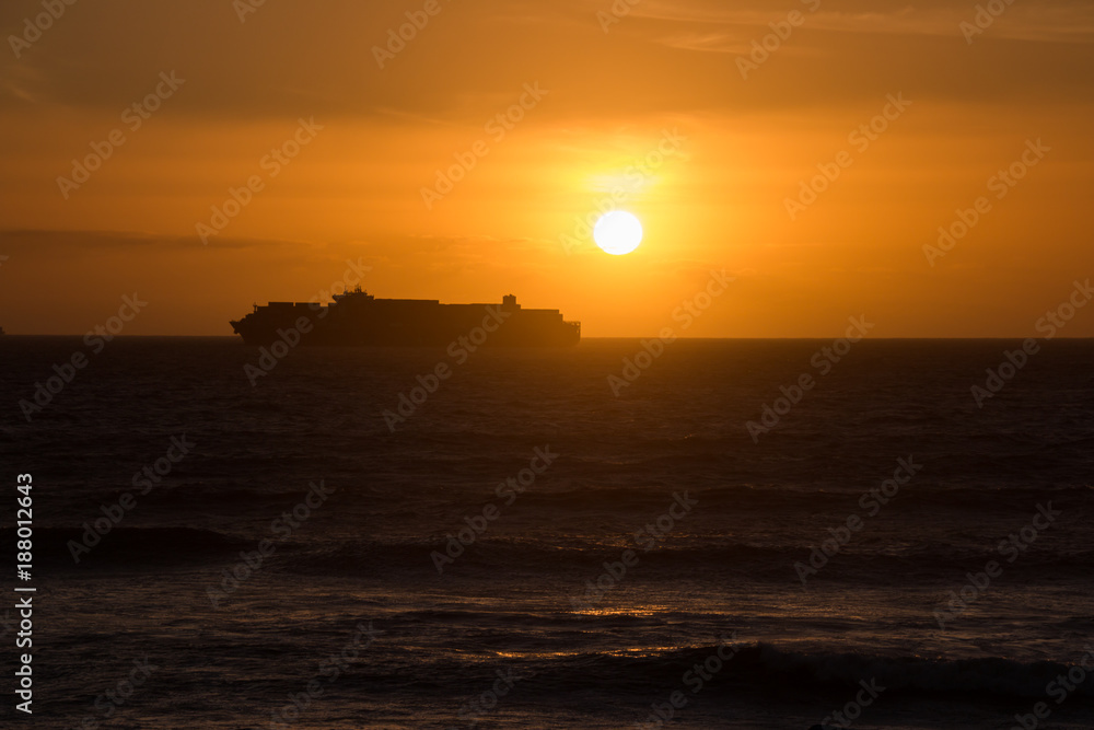 Cargo ship silhouette in orange sunset