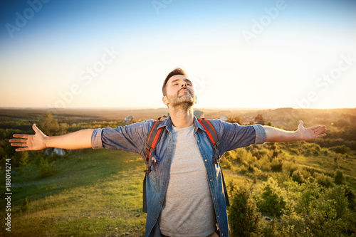 Man extending arms in happy gesture while hiking in the mountains