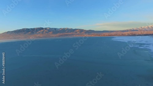 Wallpaper Mural Aerial panoramic view of a frozen lake below and forest, fields, suburbs and snowcapped mountains in the distance Torontodigital.ca