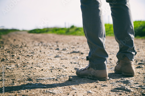 Traveler woman with hiking shoes walk on a footpath in countryside. Women's hiking boots.