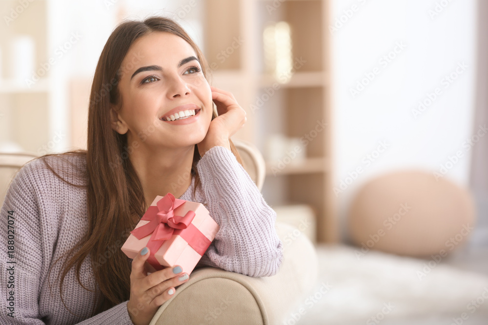 Beautiful young woman with gift for Valentine's Day at home Beautiful young woman with gift for Valentine's Day at home