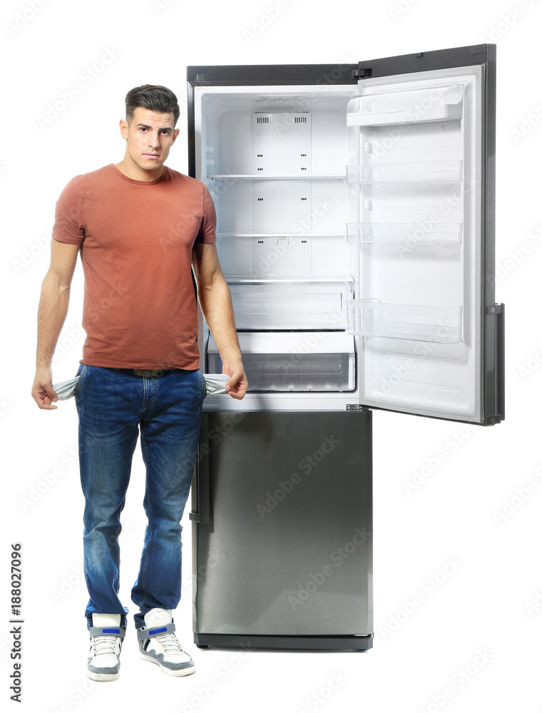 Hungry man standing near empty refrigerator, on white background Hungry man standing near empty refrigerator, on white background