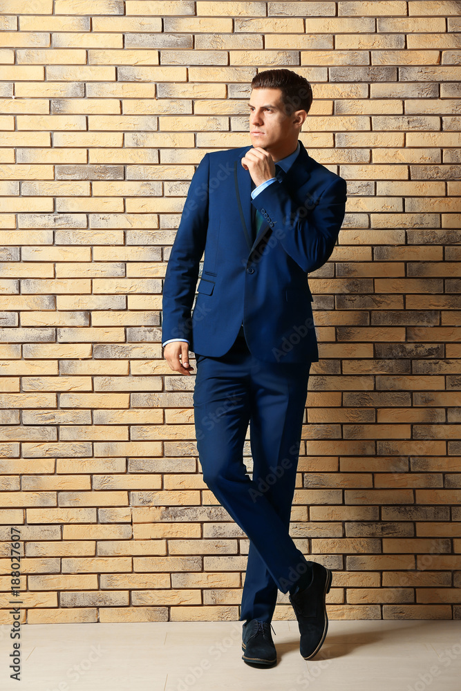 Handsome man in elegant suit near brick wall Handsome man in elegant suit near brick wall
