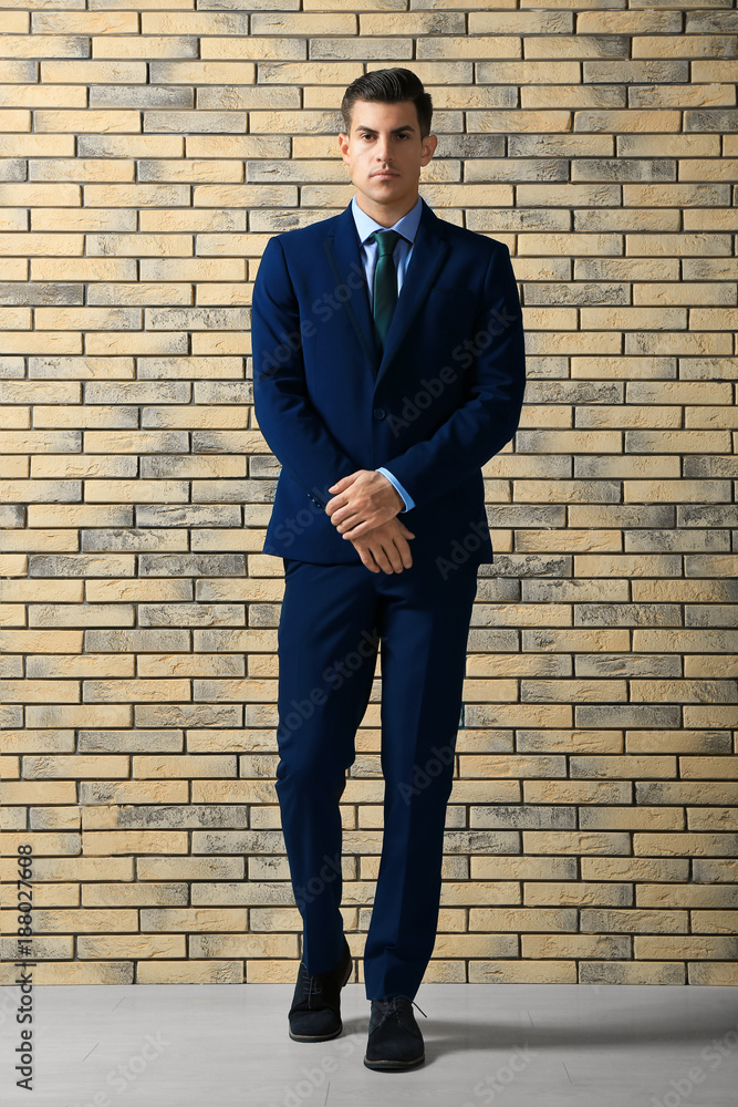 Handsome man in elegant suit near brick wall Handsome man in elegant suit near brick wall
