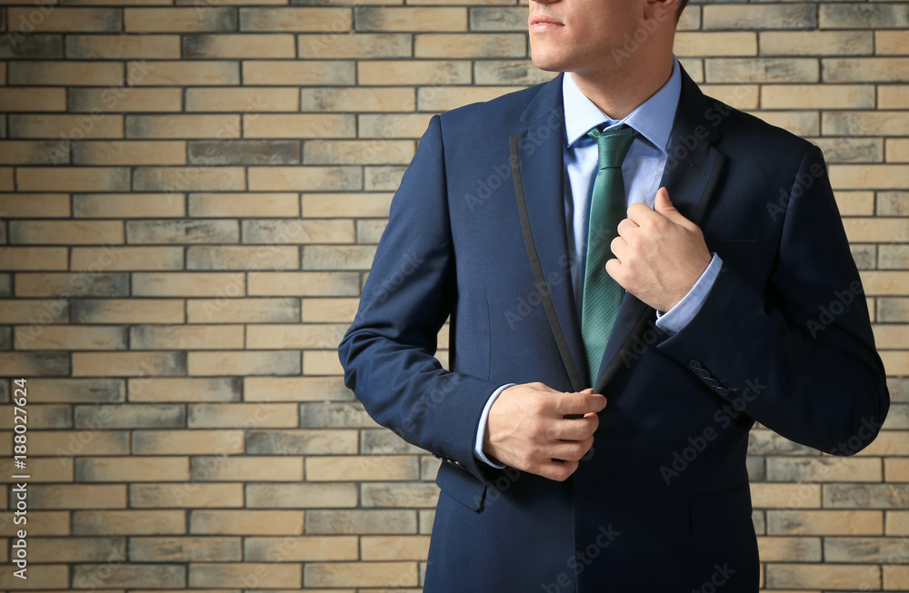 Handsome man in elegant suit against brick wall Handsome man in elegant suit against brick wall