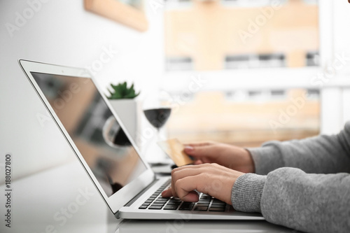 Woman using laptop while ho...