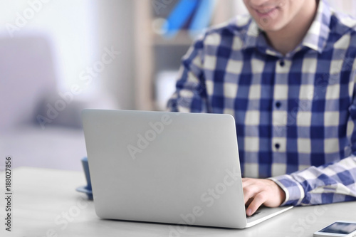 Man using laptop at table i...