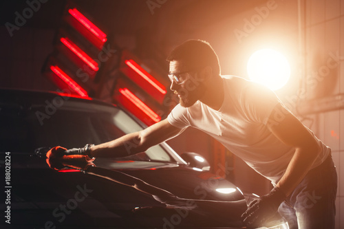 A man cleaning car with microfiber cloth, car detailing or valeting concept. Selective focus. photo