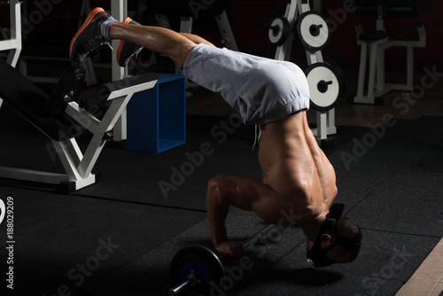 Man Exercising Push-Ups On Barbell In Elevation Mask