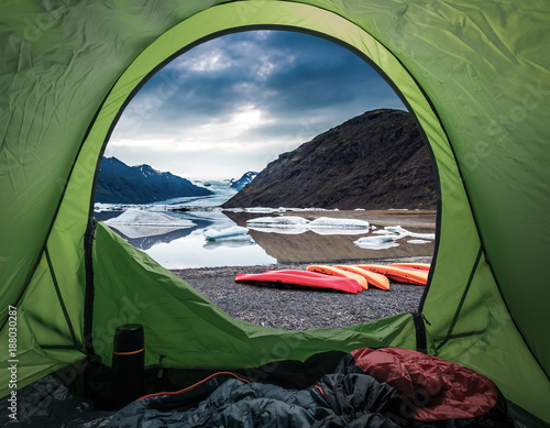 Camp by glacial lake in the mountains with kayak, Iceland