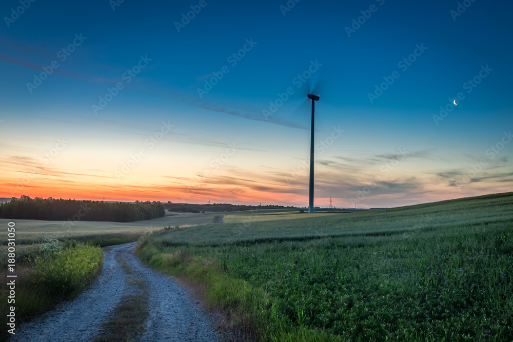 Stunning dusk over green field and wind turbines Stunning dusk over green field and wind turbines