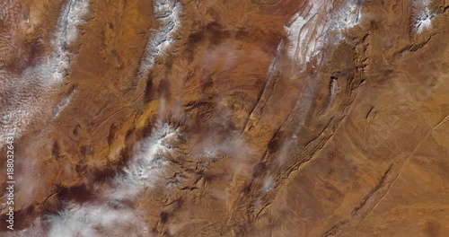 Very high-altitude overflight aerial of snow in the Sahara Desert, El Bayadh Province, Algeria. Clip loops and is reversible. Elements of this image furnished by USGS/NASA Landsat photo
