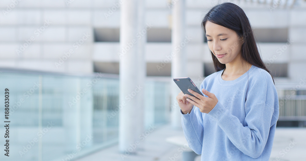 © leungchopan - Woman use smart phone at outdoor