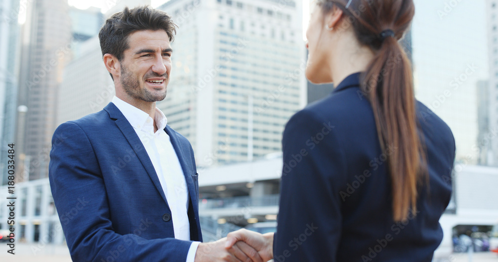 Business people greeting, hand shaking for company deal and talking to each other outside office Business people greeting, hand shaking for company deal and talking to each other outside office