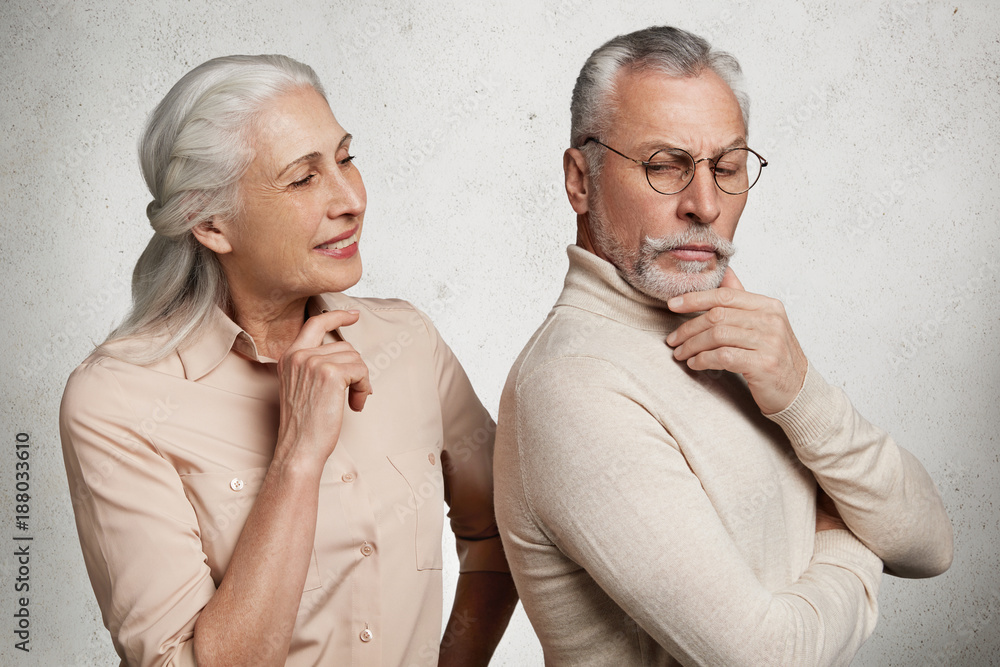 Abused angry elderly man in eyewear stands back to his wife, being ...