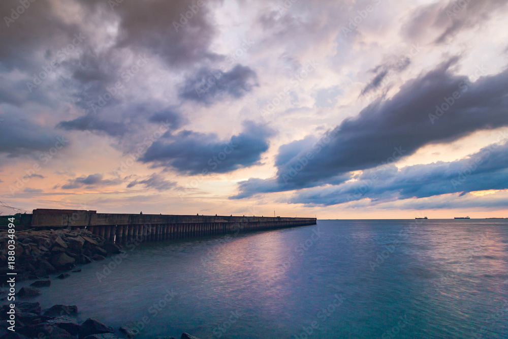 Long exposure sunset of a jetty with beautiful dramatic clouds.