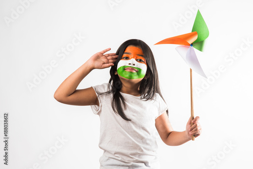 indian girl with paper windmill toy made up of tricolour or indian flag colours. Saluting, looking at camera or with red heart toy, celebrating 26 January republic day or 15 august independence day
 photo