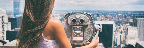 New York city tourist looking at view of NYC skyline with binoculars. Tourism in the United States of America travel banner panorama lifestyle people. American vacation.