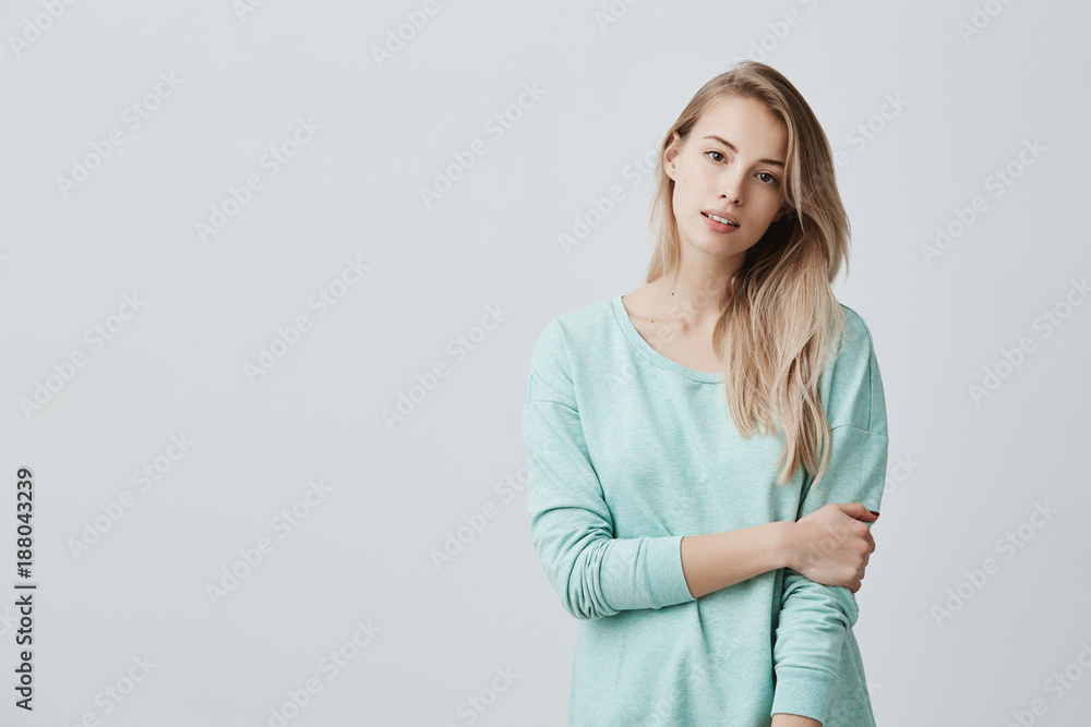 Cheerful european girl with parted lips, rejoicing her life, dressed casually standing isolated against grey wall background. People, beauty, youth and happiness concept Cheerful european girl with parted lips, rejoicing her life, dressed casually standing isolated against grey wall background. People, beauty, youth and happiness concept