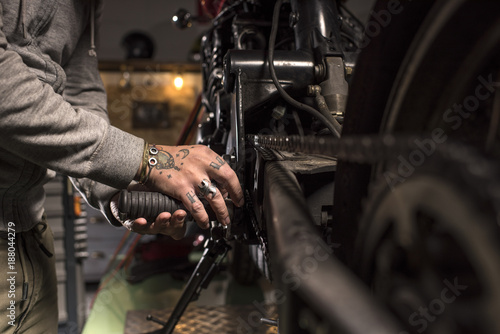 Close-up of mechanic fixing a motorbike photo
