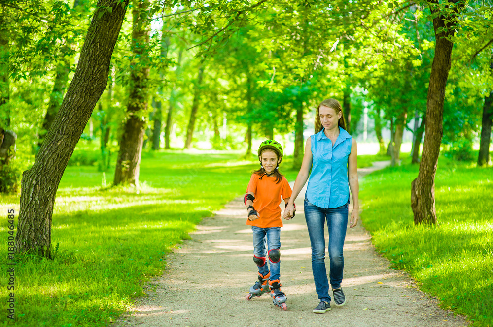Mother teaches her daughter to ride roller skates. Space for text