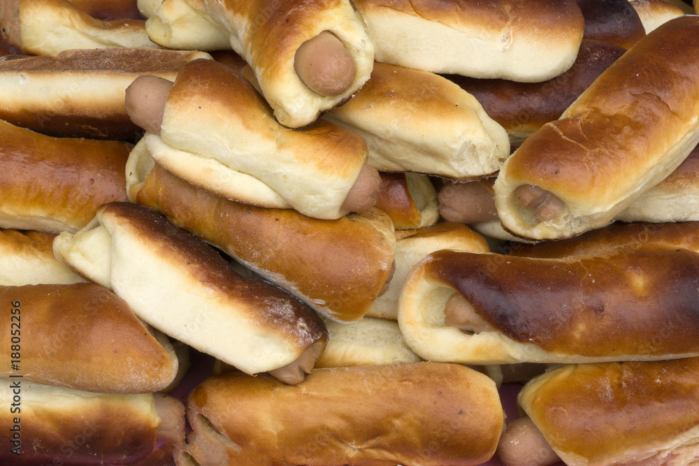 Freshly baked small buns in a ceramic bowl. Sausage in the dough. The top view