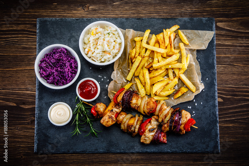 Kebabs - grilled meat with french fries and vegetables on white background
