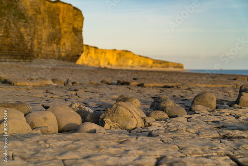 The stones and cliffs of Llantwit Major Beach in the evening sun, South Glamorgan, Wales, UK photo