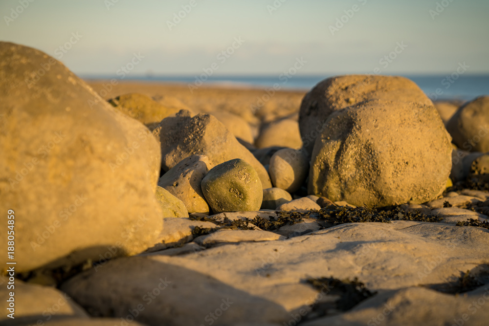The stones of Llantwit Major Beach in the evening sun, South Glamorgan, Wales, UK