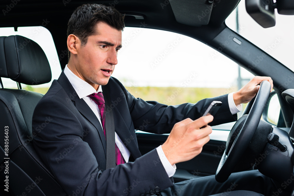 Man texting on his phone while driving by car Man texting on his phone while driving by car