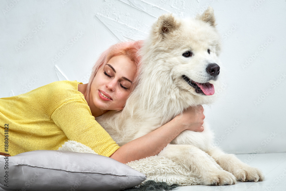 portrait lying on floor plaid natural cute girls in a yellow jacket and full lips and beautiful white dog concerned what's happening up ahead. Positive human emotion, facial expression, feelings. portrait lying on floor plaid natural cute girls in a yellow jacket and full lips and beautiful white dog concerned what's happening up ahead. Positive human emotion, facial expression, feelings.