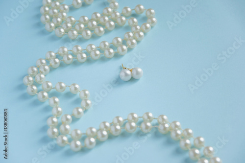 White pearls on blue background - luxury fashion concept