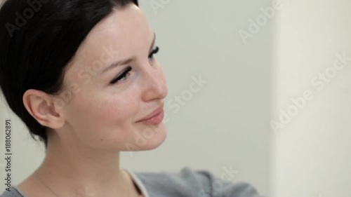 A beautiful girl with blue eyes admires her eyelashes after their extensions photo