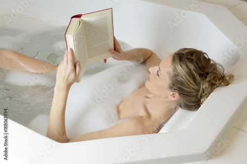 Frau liest Buch in Badewanne photo