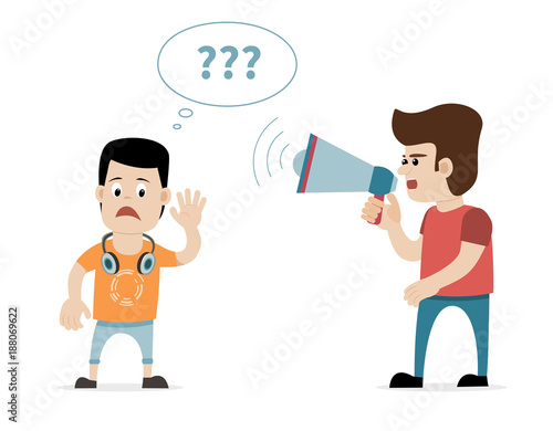 A man shouting with megaphone at hearing impaired young boy photo