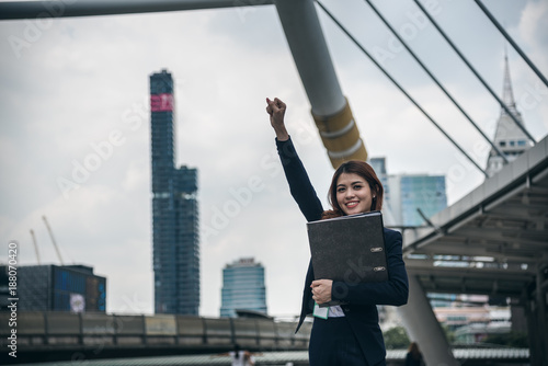 Portraits of beautiful asian woman look cheerful and confidence is standing and feeling success with work while holding folder document.