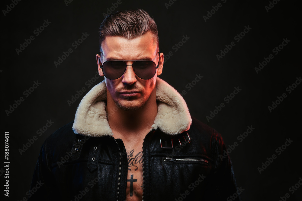 A macho stylish man on a dark background. A macho stylish man on a dark background.