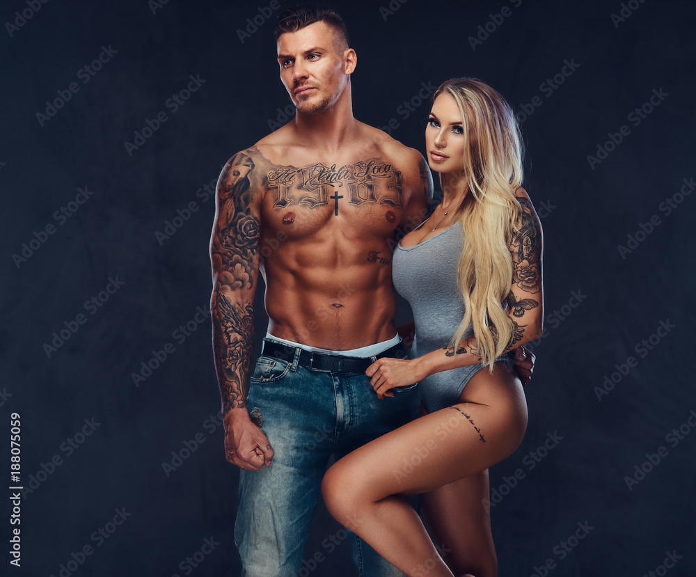 A sexy fit couple, posing on a dark blackground. A sexy fit couple, posing on a dark blackground.