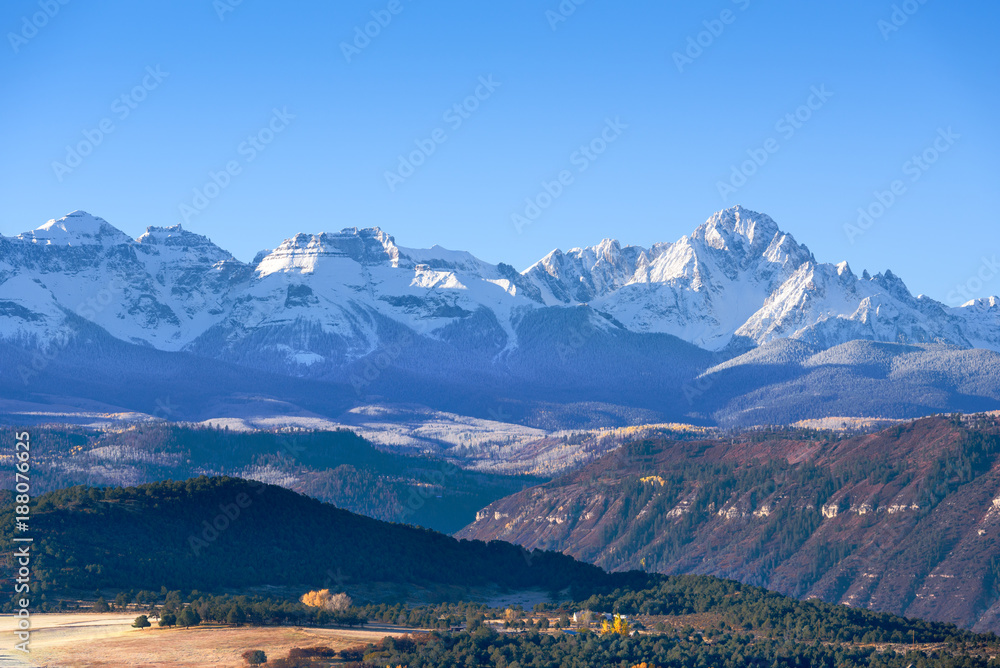 Beautiful view of snow covered Sneffels Range in a bright daylight blue sky in the morning light near Ridgway, Colorado, USA.