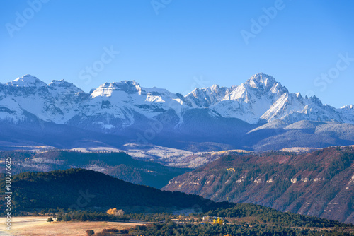 Beautiful view of snow covered Sneffels Range in a bright daylight blue sky in the morning light near Ridgway, Colorado, USA. photo