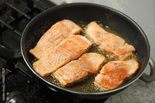  large steak of salmon is fried in sunflower oil.