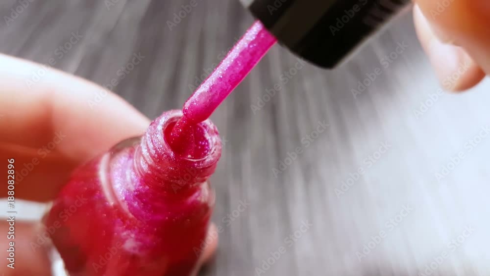 Pink glitter nails polish in bottle with brush. Pink glitter nails polish in bottle with brush.