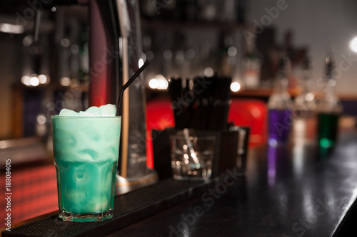 Green cocktail with ice on the bar