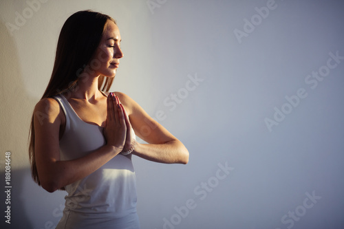 woman practicing yoga, holding palms together in namaste mudra, relaxed and peaceful.