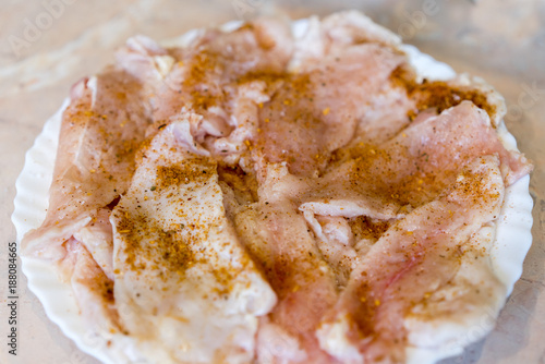 Raw chicken fillet sprinkled with spices photo