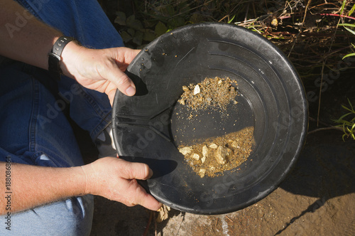 Fototapeta gold panning hoping to strike it rich