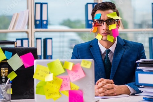 Businessman with reminder notes in multitasking concept photo