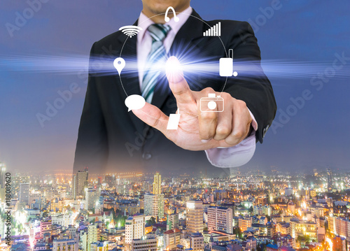 Businessman hands press the button pushing icon of touch screen on city view