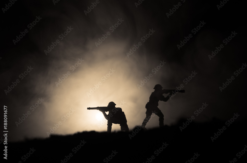 Military silhouettes of soldiers against the backdrop of dark foggy sky. Battle scene with explosion and burning clouds behind fighing soldiers. Toy decoration Military silhouettes of soldiers against the backdrop of dark foggy sky. Battle scene with explosion and burning clouds behind fighing soldiers. Toy decoration