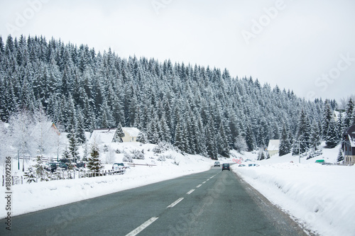 Mountain winter road goes through the village © scharfsinn86